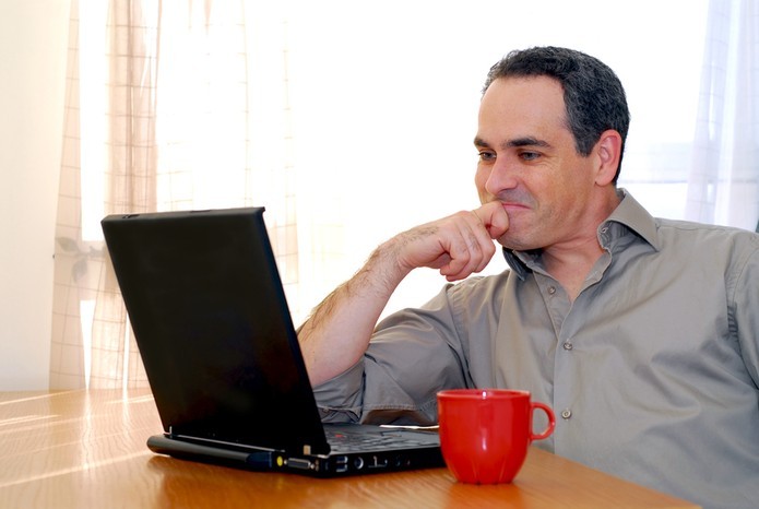 um homem sentado na frente de um laptop