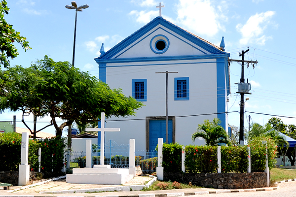 uma igreja azul e branca com uma cruz na frente