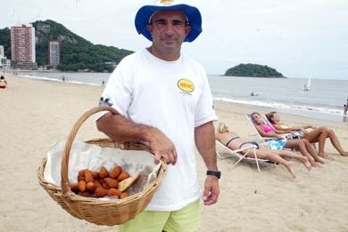 um homem segurando uma cesta de comida na praia