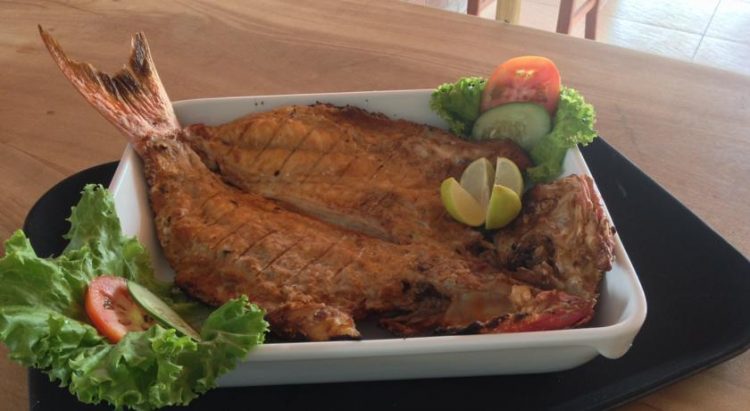 um prato de comida com peixe e legumes