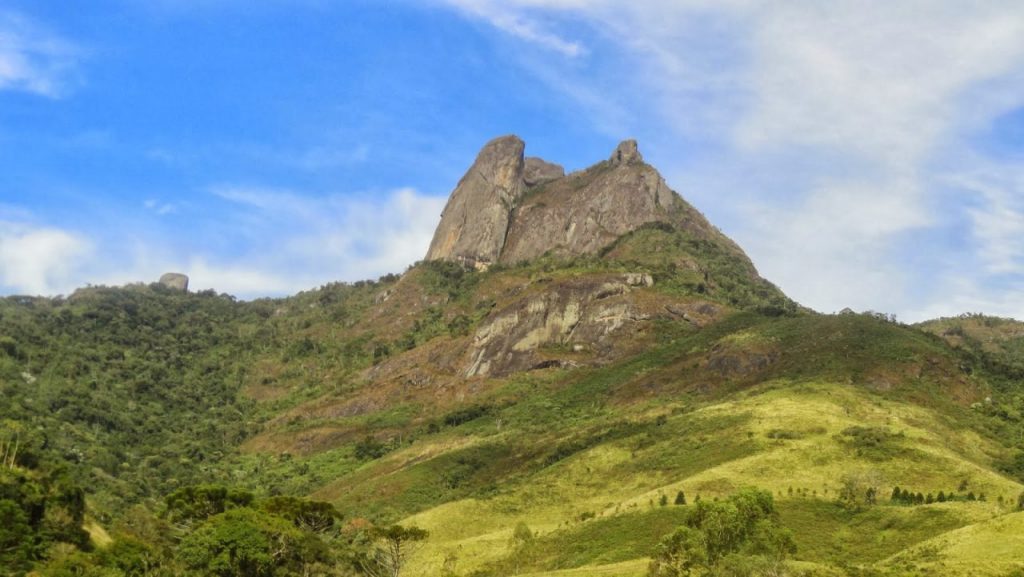 uma grande montanha com algumas árvores ao lado dela