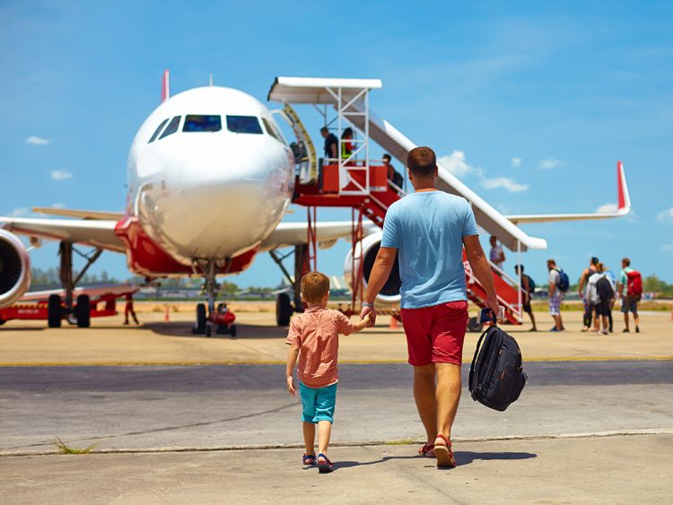 um homem e uma criança caminhando em direção a um avião