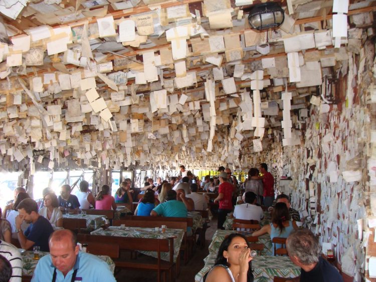 um grupo de pessoas sentadas em mesas em um restaurante