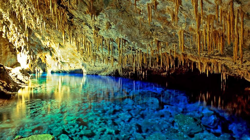 uma piscina azul em uma caverna cheia de água
