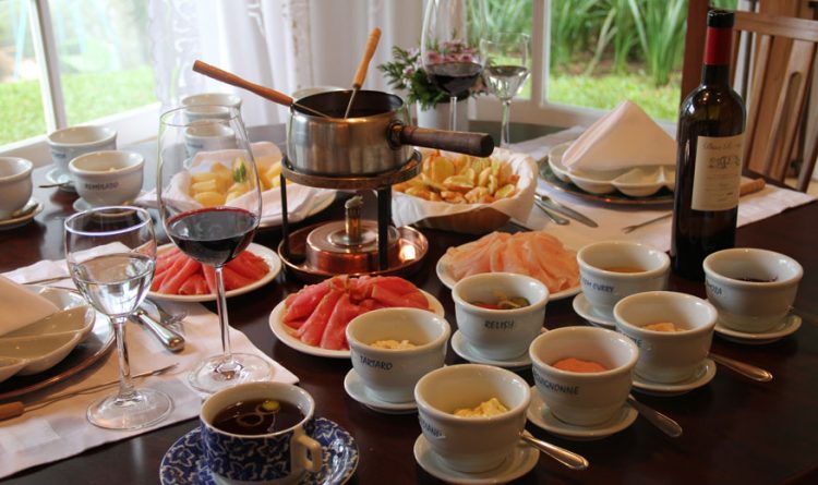 uma mesa posta com vinho, pratos e tigelas de comida