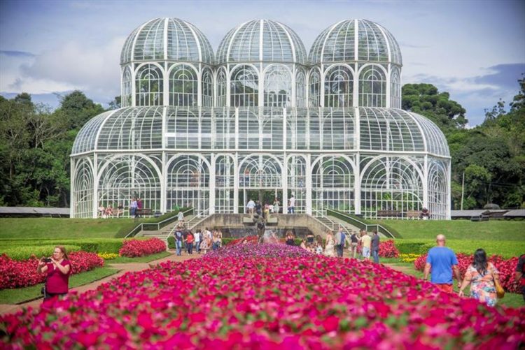 um grupo de pessoas em frente a um jardim de flores