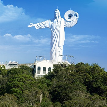 uma grande estátua de Jesus no topo de uma colina