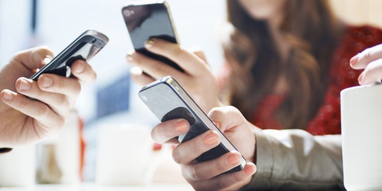 hands texting with mobile phones in cafe