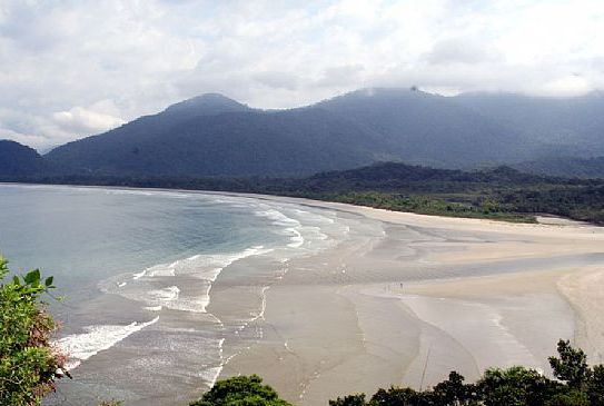 uma vista de uma praia com montanhas ao fundo