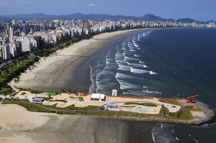 uma vista aérea de uma praia com uma cidade ao fundo