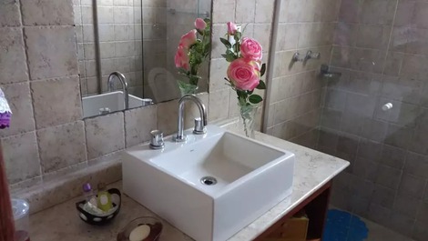 Banheiro social com lavatório, espelho e armário